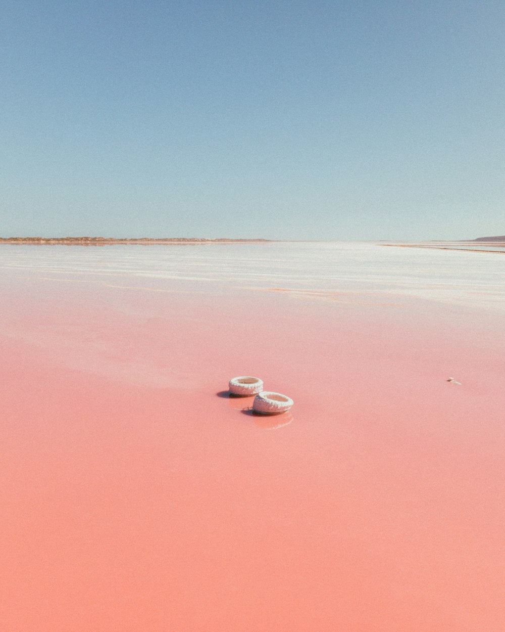 a boat sitting on top of a pink lake
