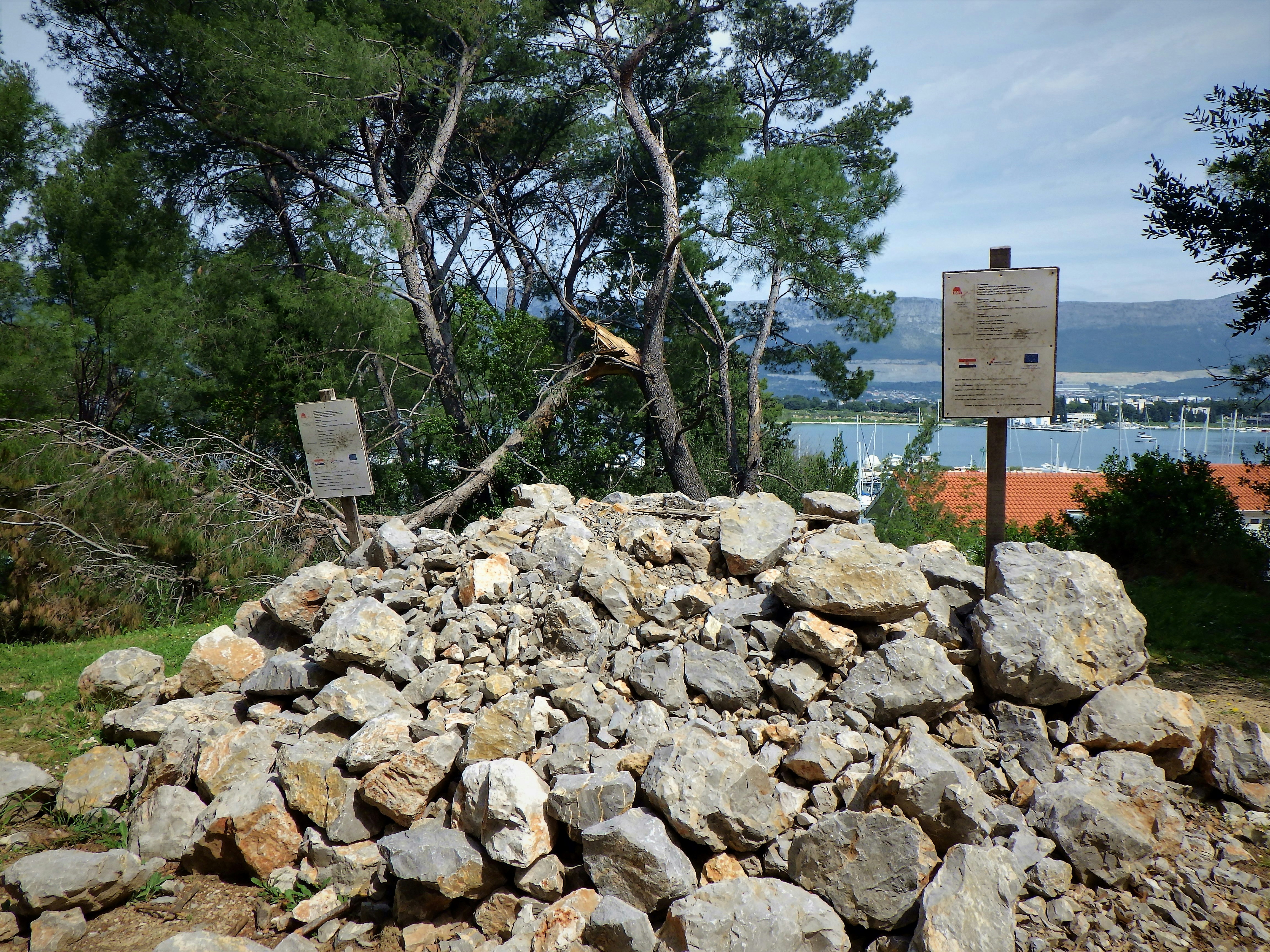 a pile of rocks with a sign in the background