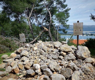 a pile of rocks with a sign in the background