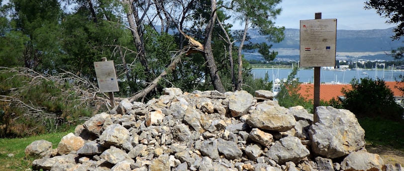 a pile of rocks with a sign in the background