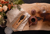 A steaming cup of fragrant Chinese tea beside a rustic clay teapot on a bamboo tray.