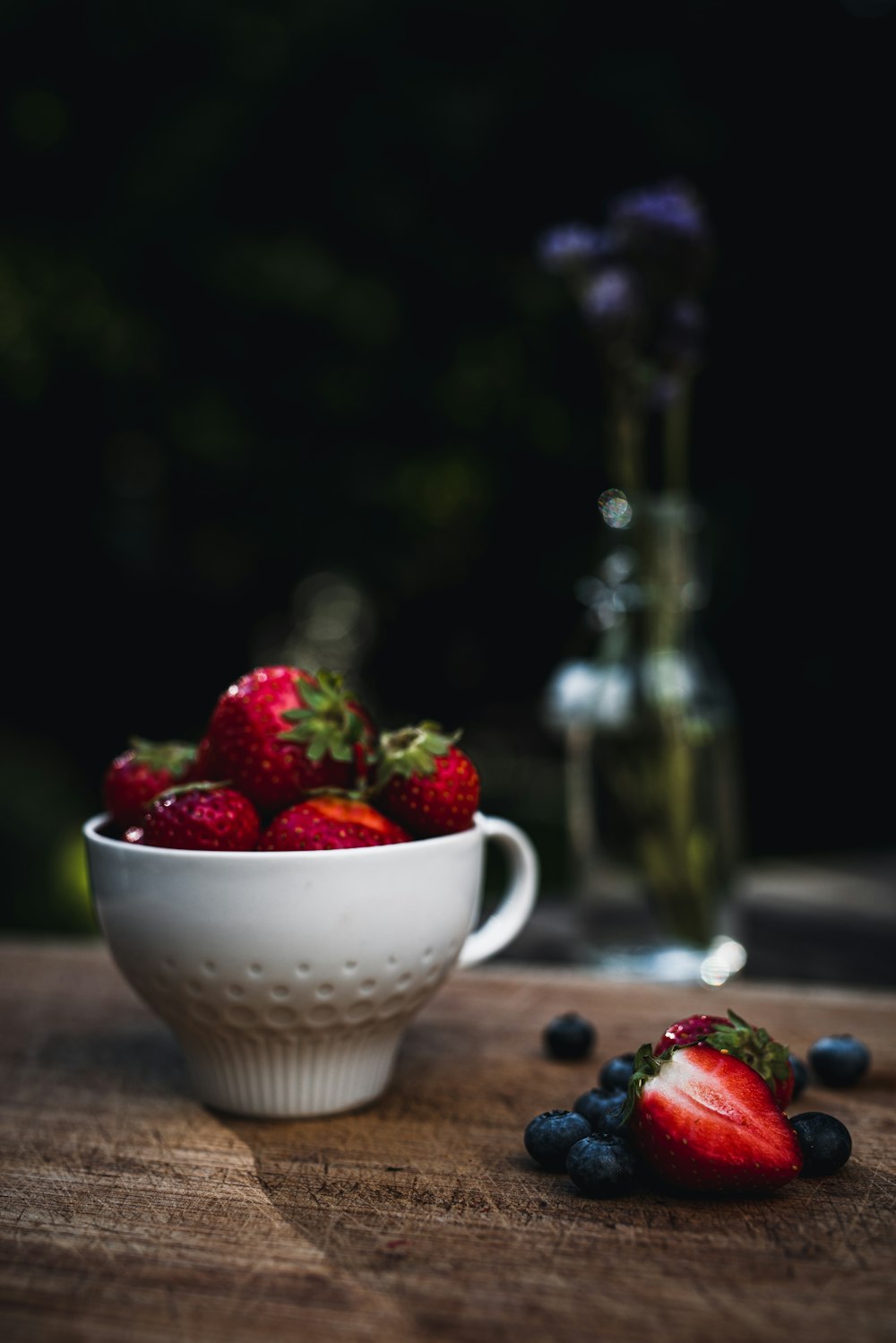 a bowl of strawberries and blueberries on a table