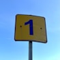 a blue and yellow street sign with the number one on it