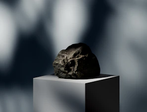 A minimalist stone sculpture displayed elegantly against a dark background.