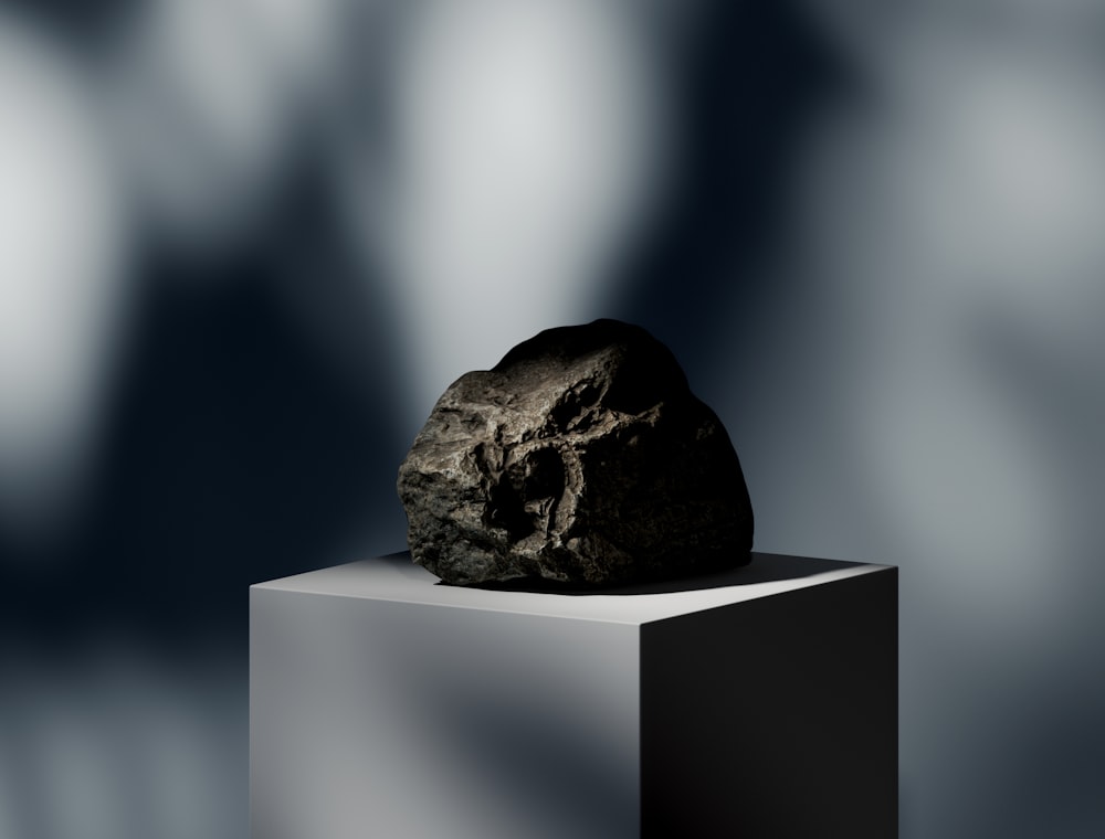 a rock sitting on top of a white block