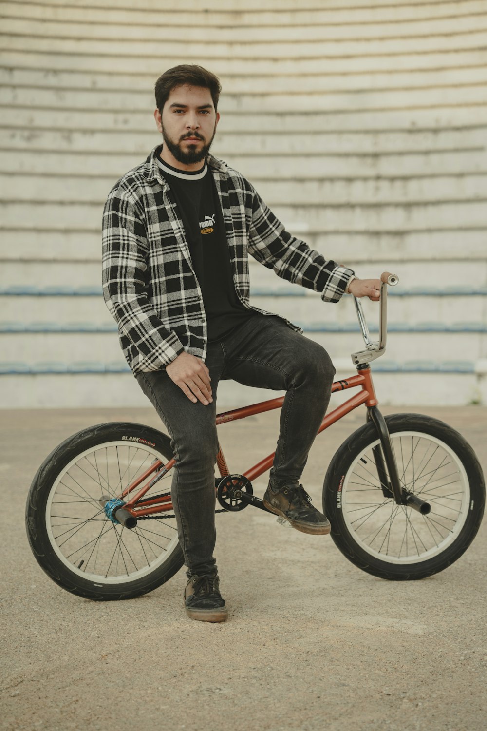 a man sitting on top of a red bike