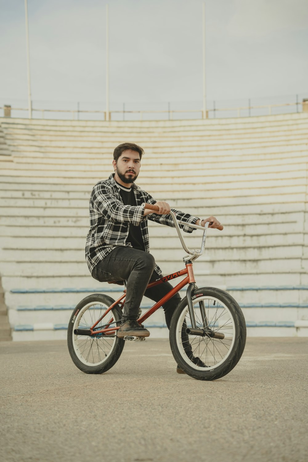 a man riding a bike in front of a stadium