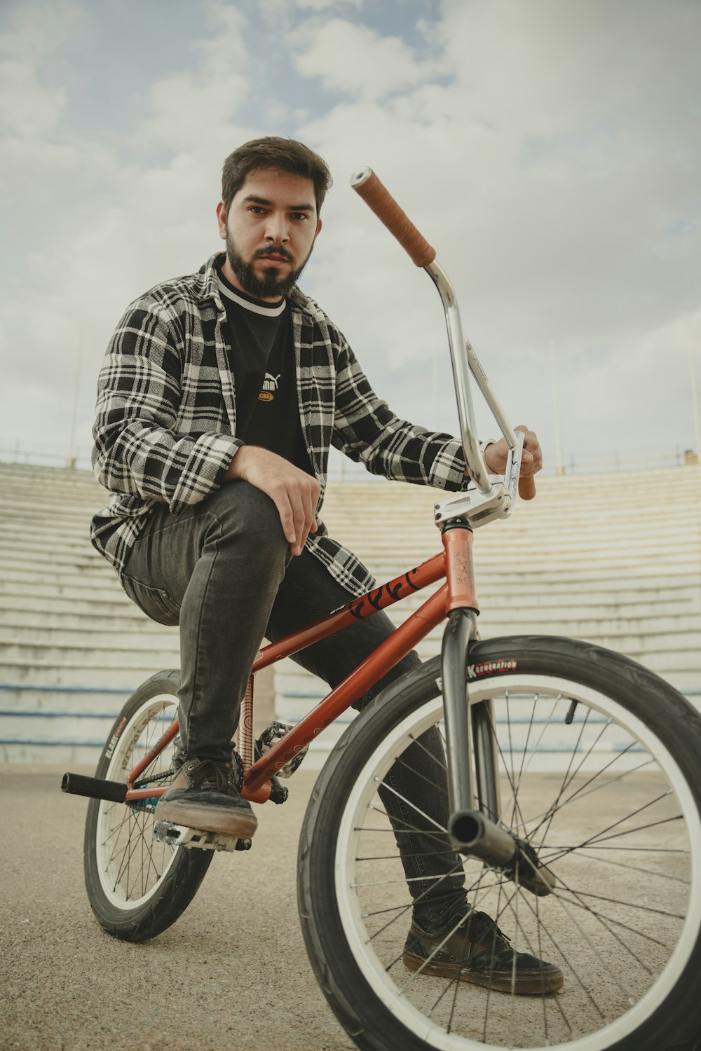 a man sitting on top of a red bike