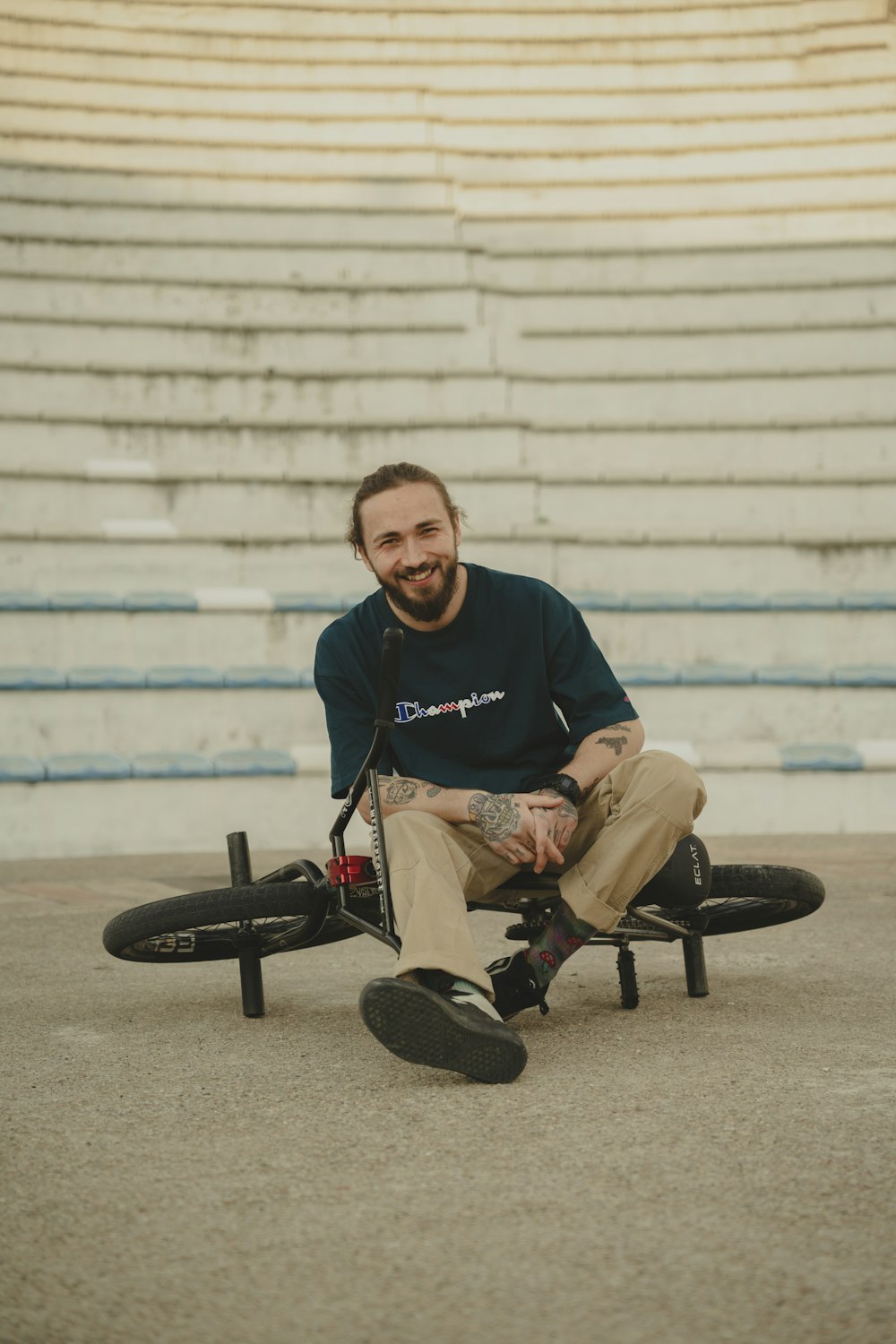 a man sitting on top of a skateboard in front of a bleachers