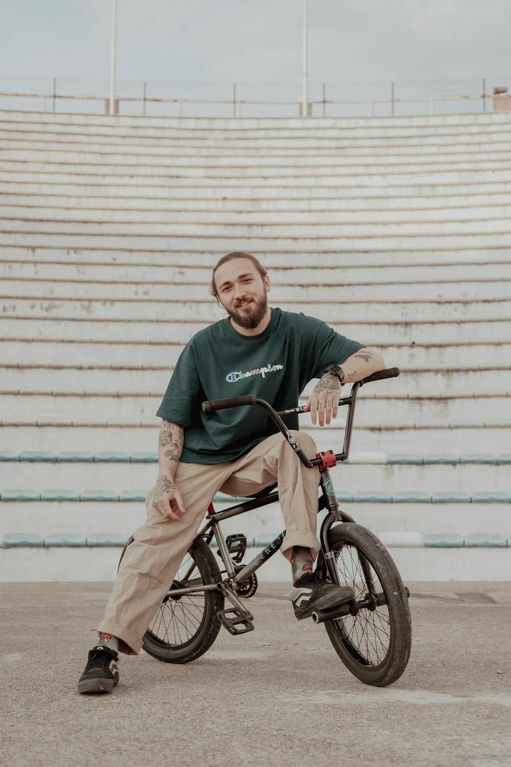 a man sitting on a bike in front of a bleacher