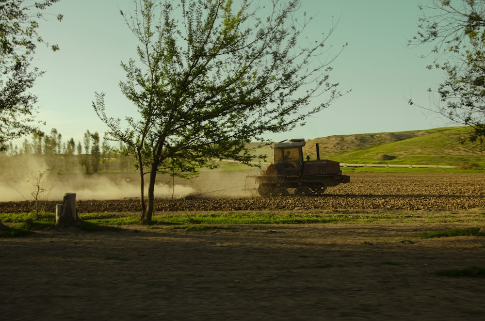 a tractor plowing a field with dust