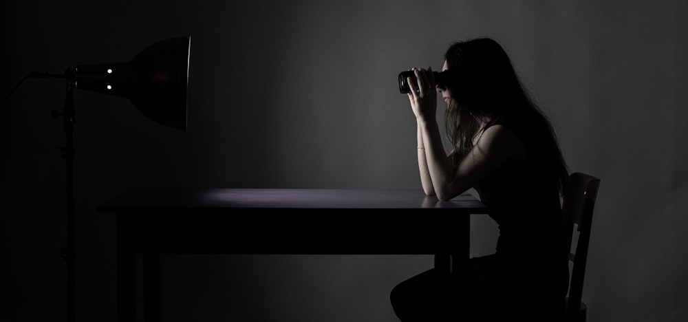 a woman sitting at a table in the dark