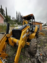 An operator skillfully maneuvering a backhoe loader in a tight space.