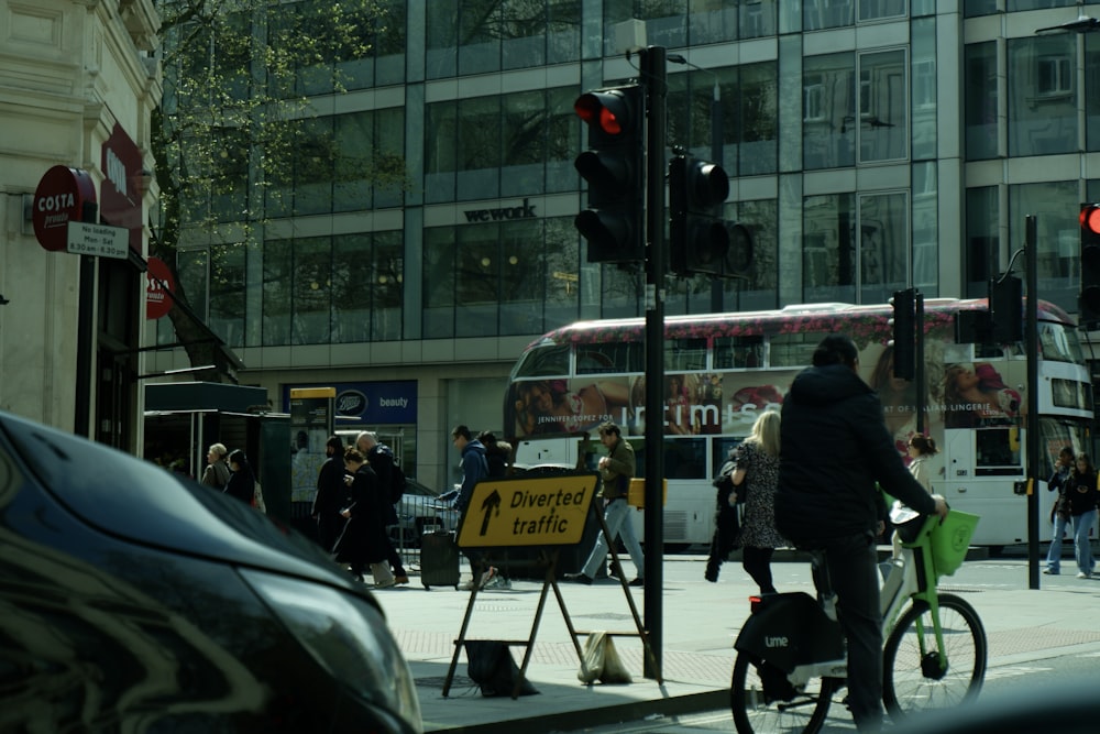 a man riding a bike down a street next to a traffic light