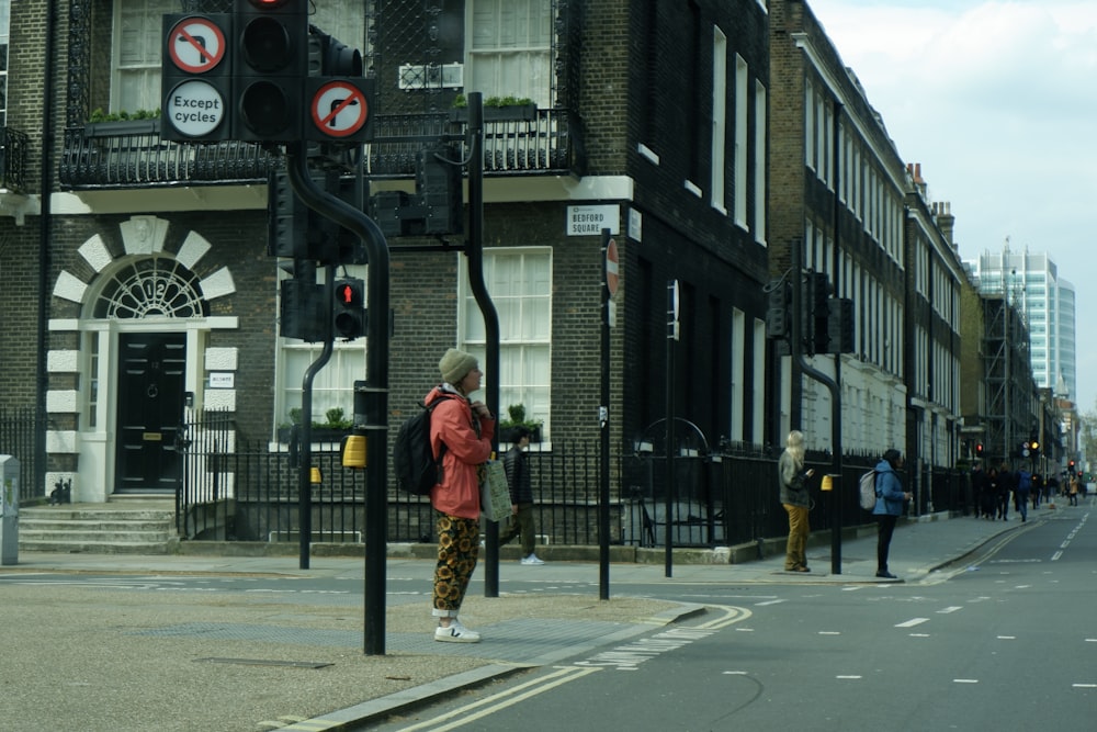 a man standing on the side of a street next to a traffic light