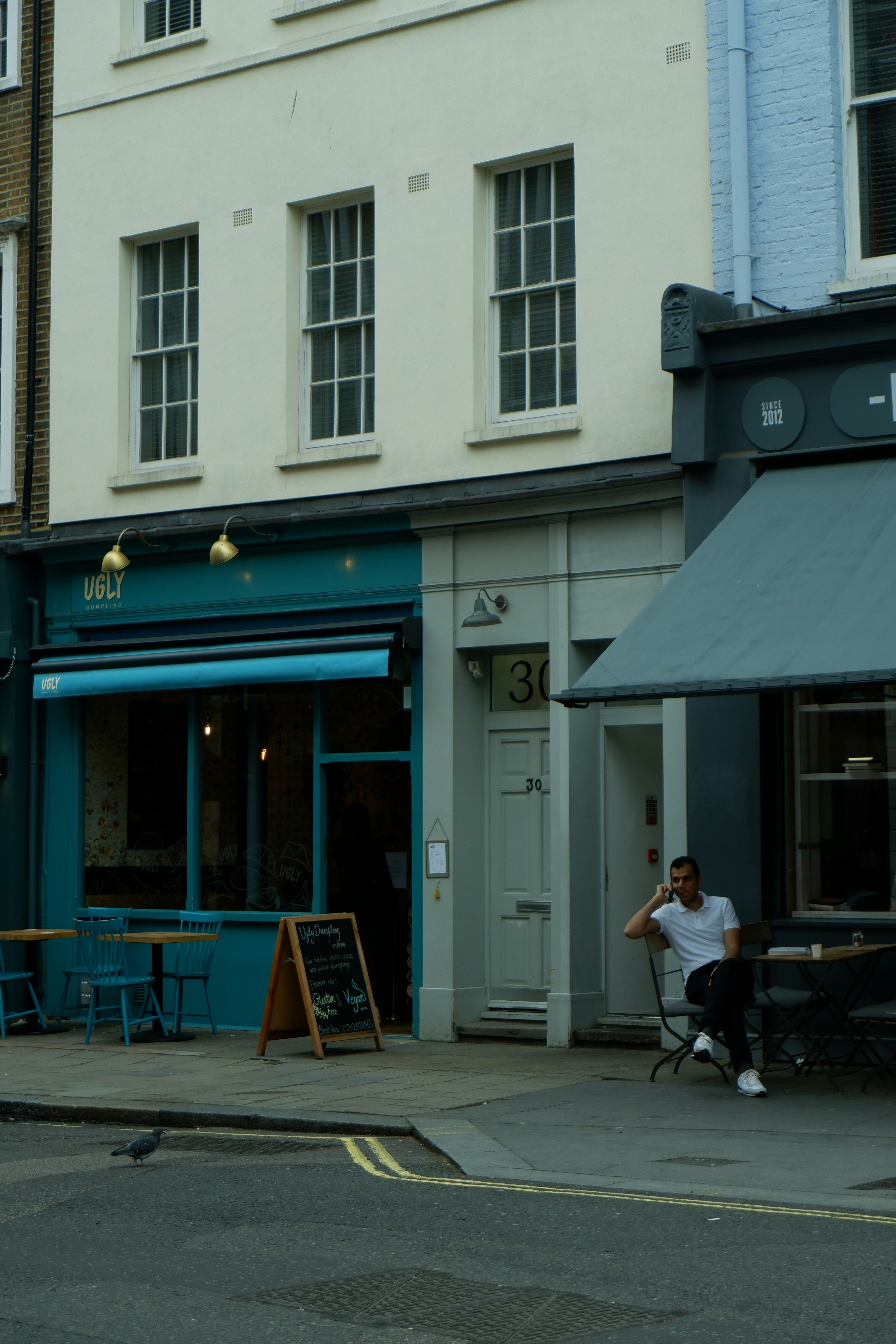 a man sitting on a bench in front of a building