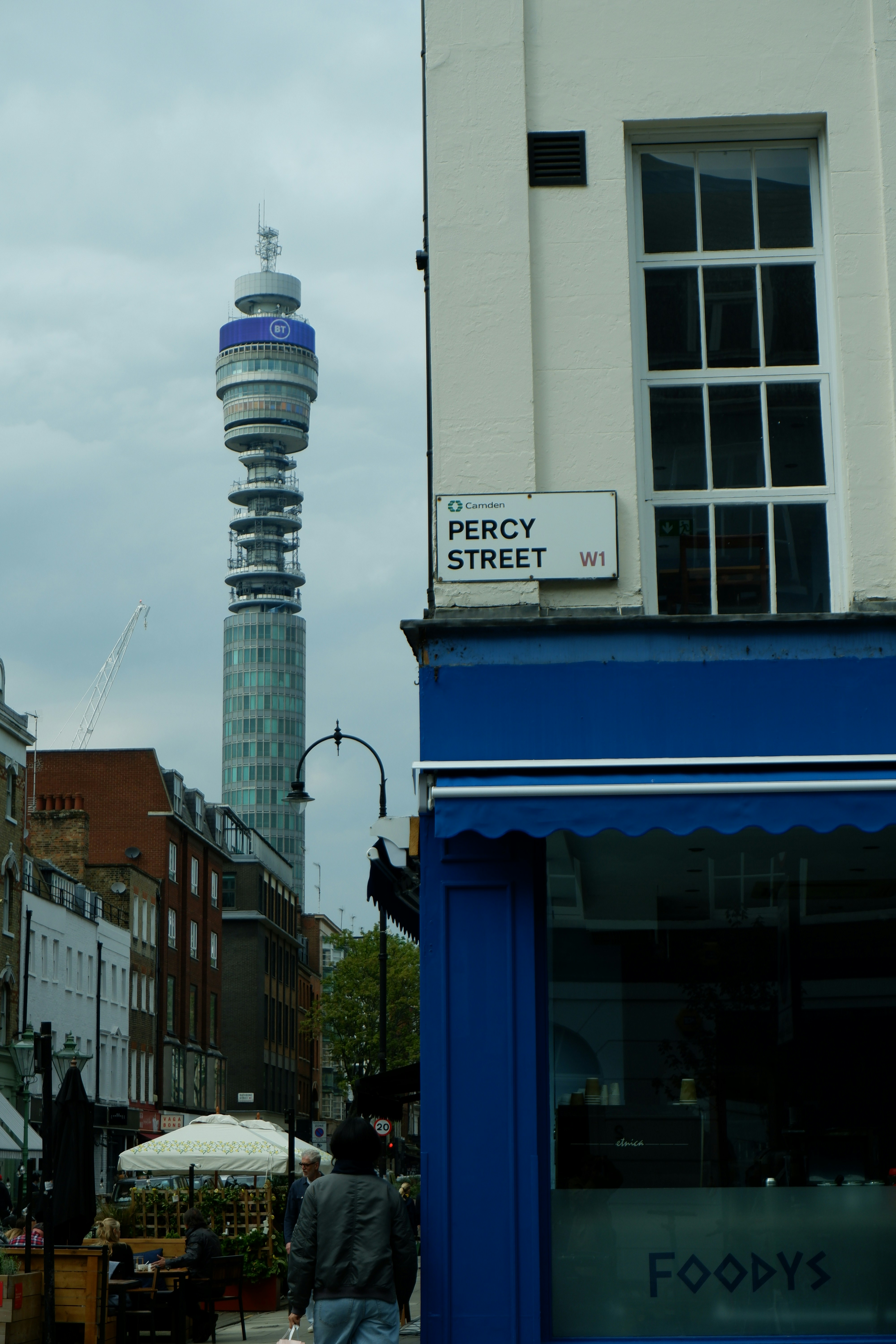 a man walking down a street next to a tall building