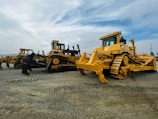 Group of trainees attentively learning about bulldozer operation outdoors