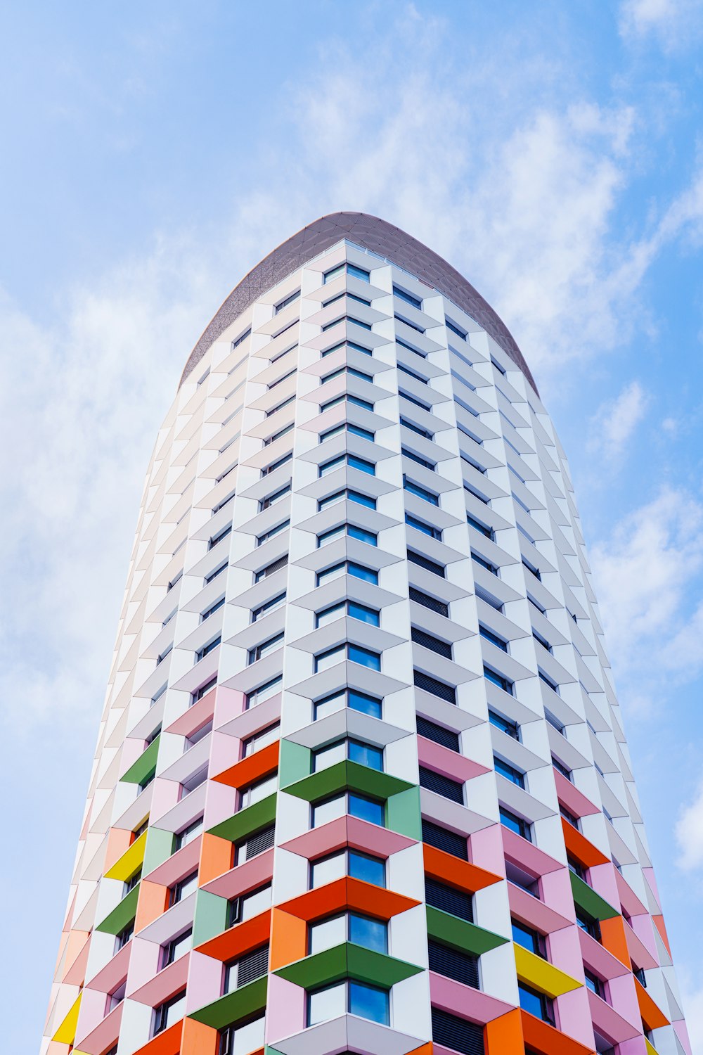 a tall multicolored building with a sky background