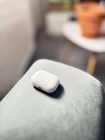 Vibrant floral patterned AirPod case resting on a wooden table.
