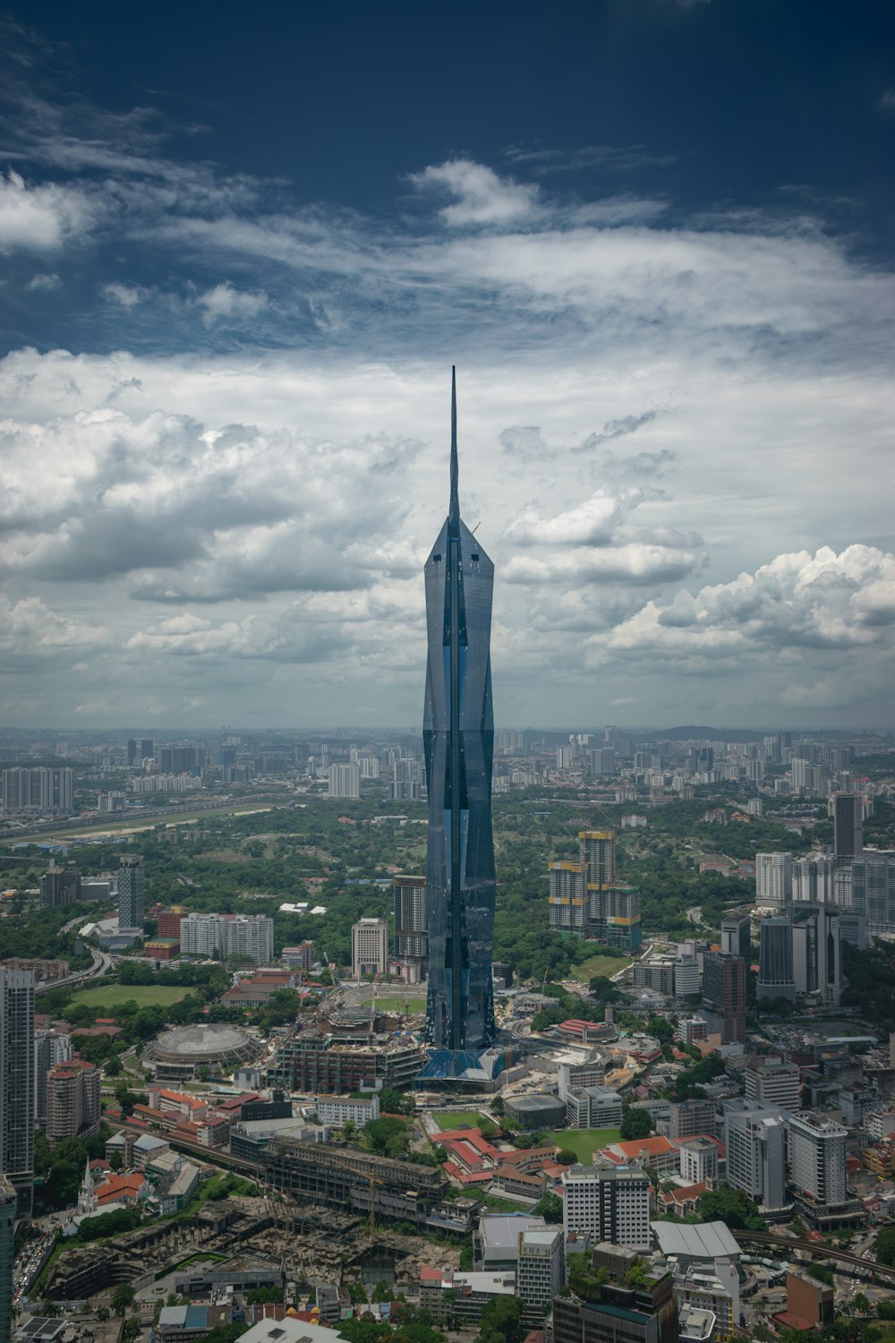 a tall building towering over a city under a cloudy sky