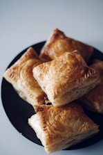 a black plate topped with pastries on top of a table