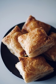 a black plate topped with pastries on top of a table