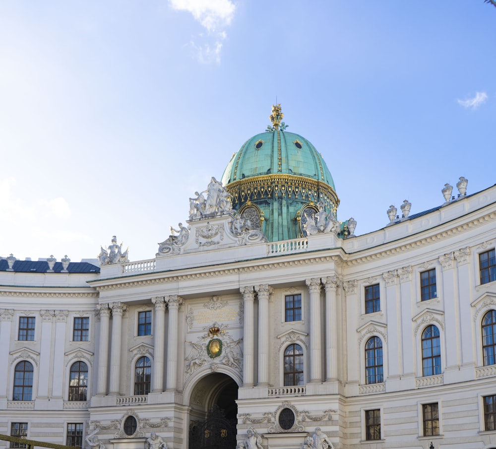 a large white building with a green dome