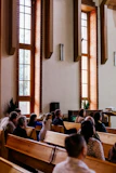 a group of people sitting in pews in a church
