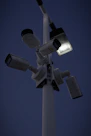 Modern security camera mounted on a building exterior at dusk.