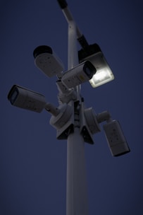 Close-up of IP security cameras mounted on a building exterior at sunset.
