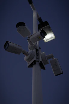 Security cameras and bright spotlights illuminating the storage facility at dusk.
