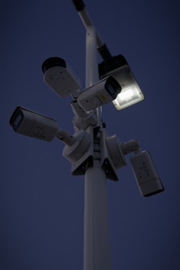 Security camera mounted on a building overlooking a city street at dusk