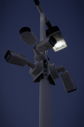 Night view of a secured commercial area with visible security cameras.