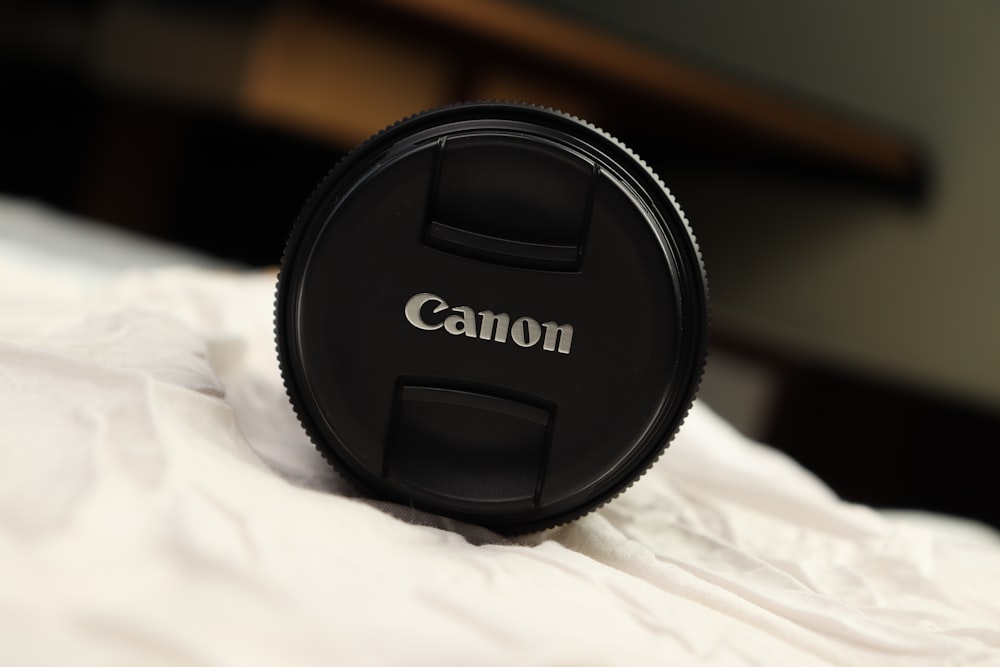 a camera lens cap sitting on top of a bed