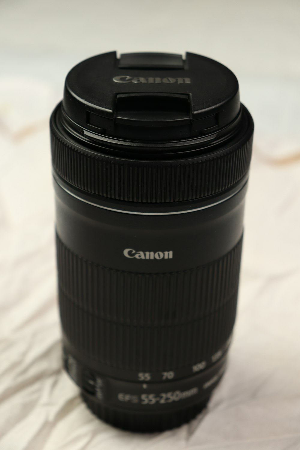 a camera lens sitting on top of a bed