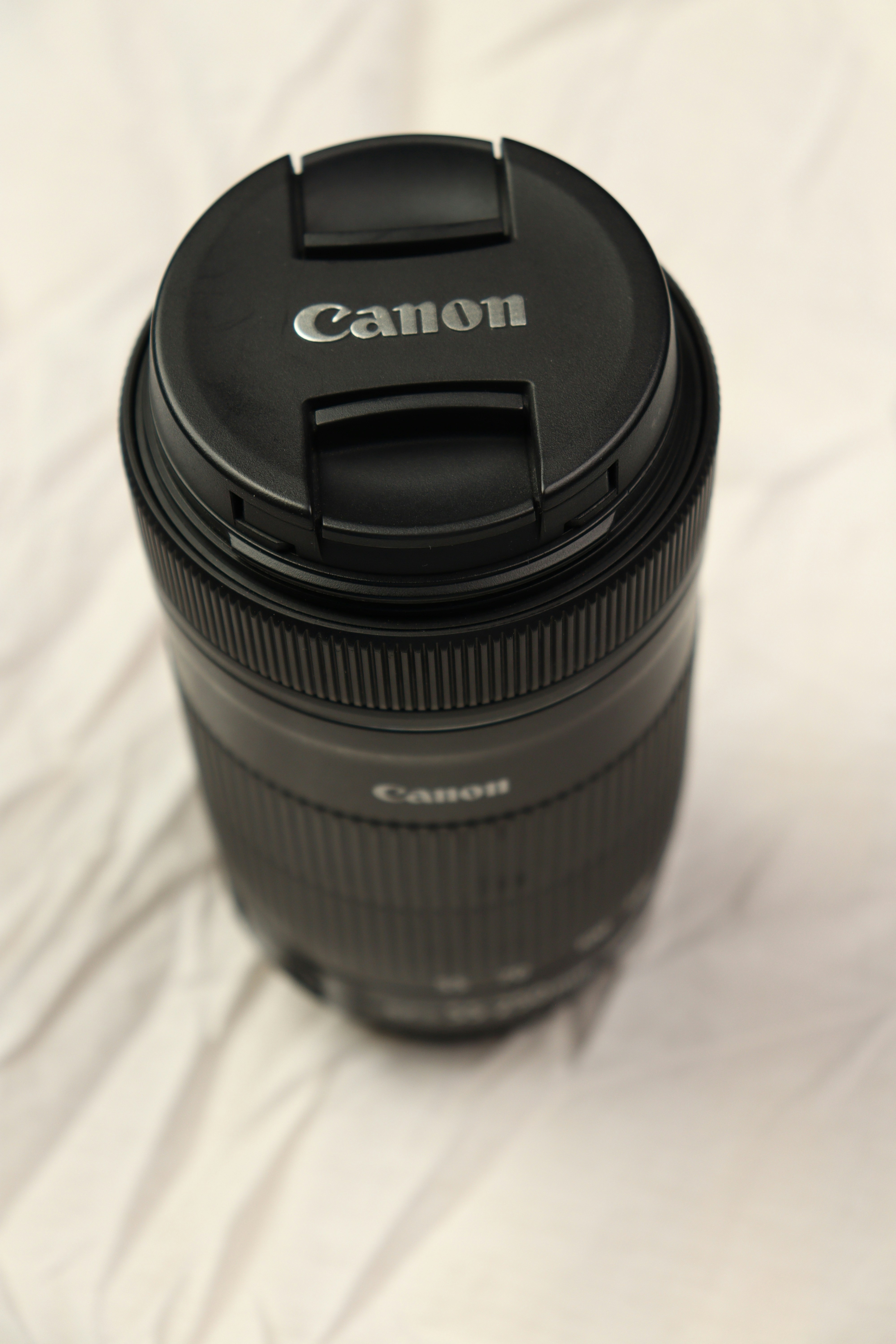 a camera lens sitting on top of a white sheet