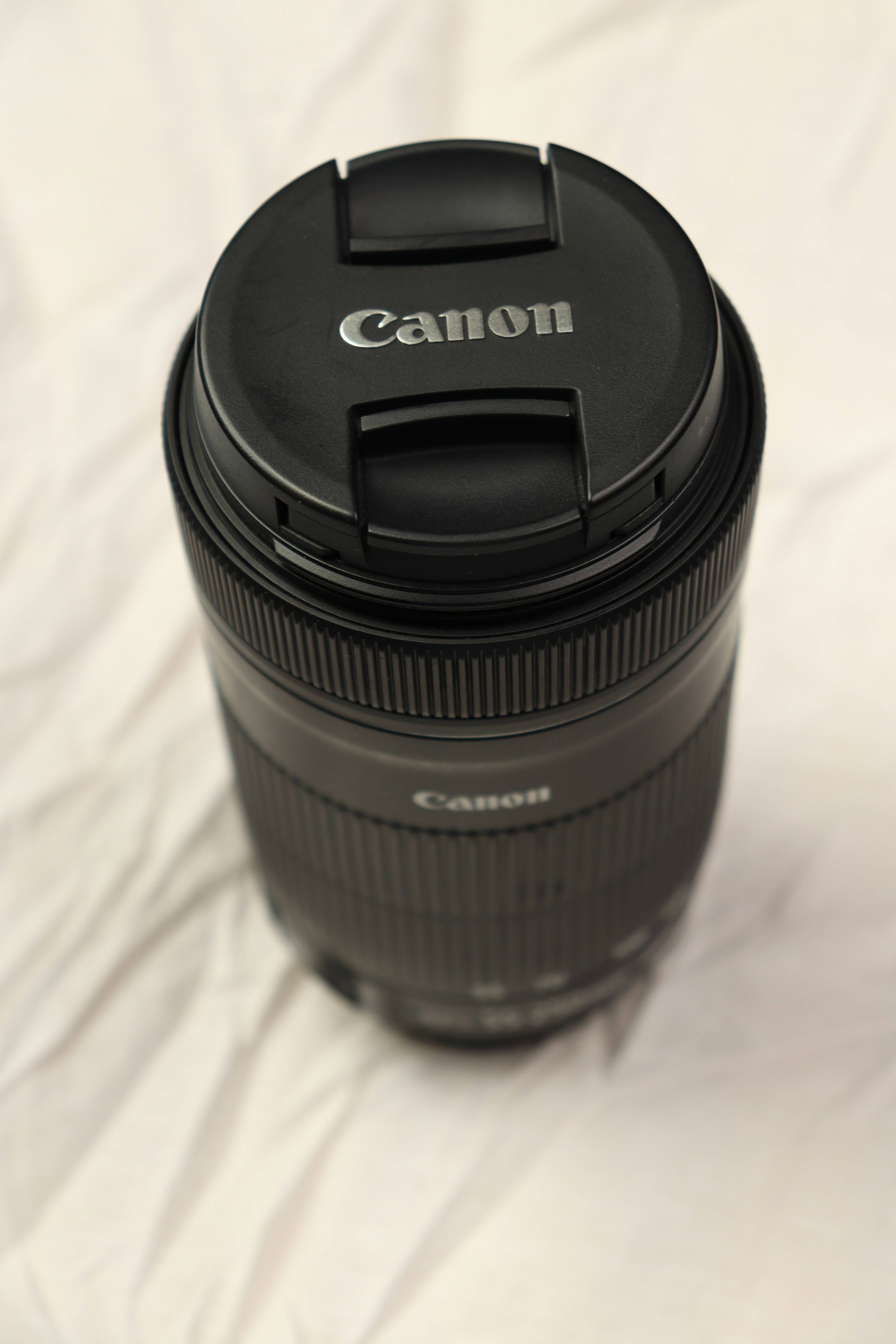 a camera lens sitting on top of a white sheet
