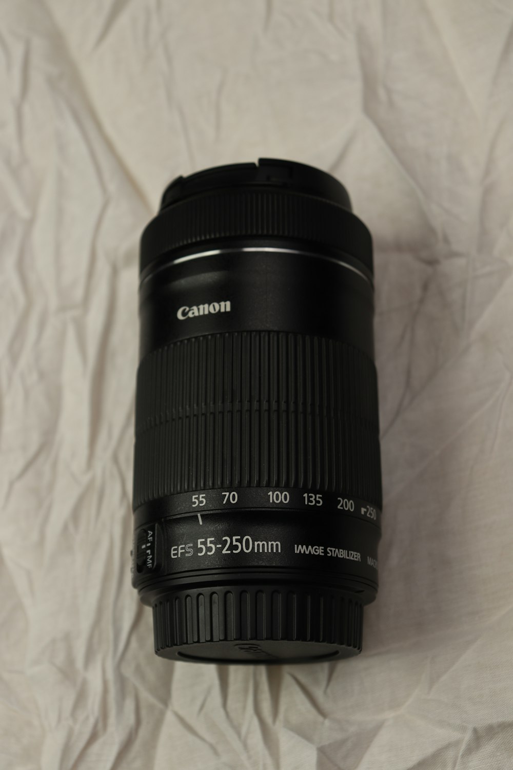 a camera lens sitting on top of a white sheet