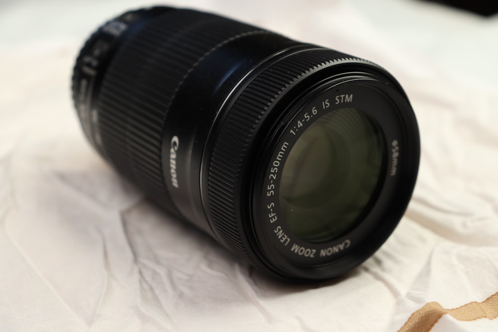 a camera lens sitting on top of a white sheet