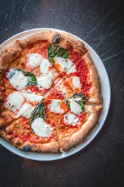 a pizza on a white plate on a table