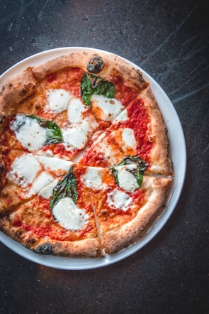 A single-serving skillet pizza with melted cheese, fresh basil, and cherry tomatoes.