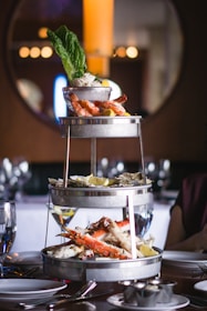 An elegant seafood platter featuring grilled prawns, fish, and lemon wedges on a rustic wooden table.