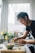 A happy woman enjoying a healthy meal in a sunlit kitchen.