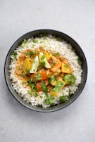 A steaming bowl of traditional Indian curry with rice.