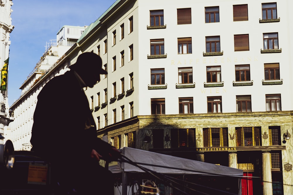 a man walking down a street next to tall buildings