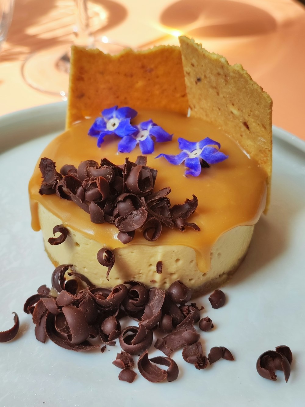 a piece of cheesecake with chocolate chips and blue flowers