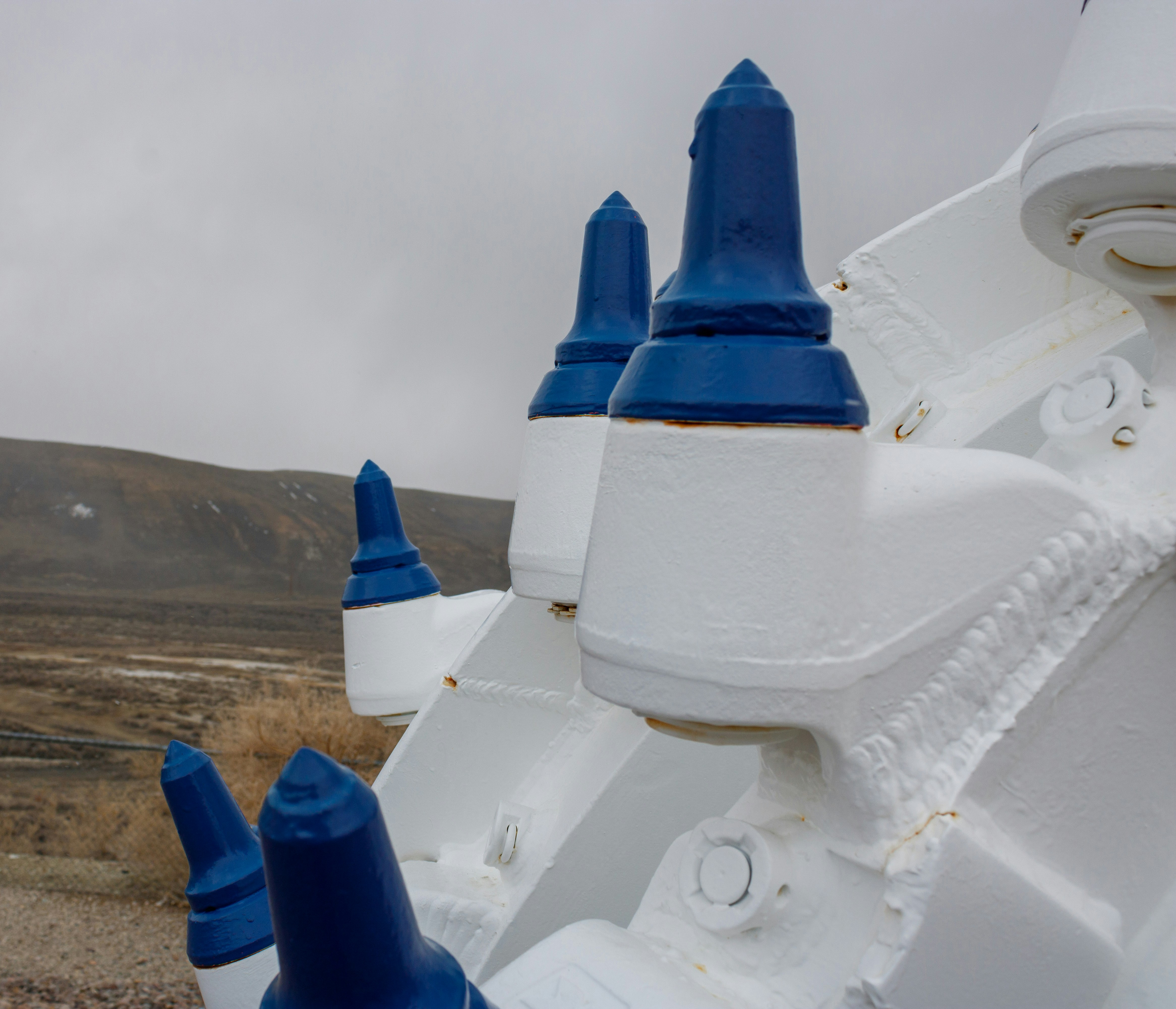 a close up of a blue and white object with a mountain in the background