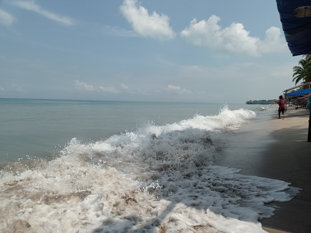 a view of a beach with waves crashing on the shore