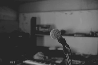 A stark black-and-white photo of a microphone against a dark background, symbolizing unfiltered voice.